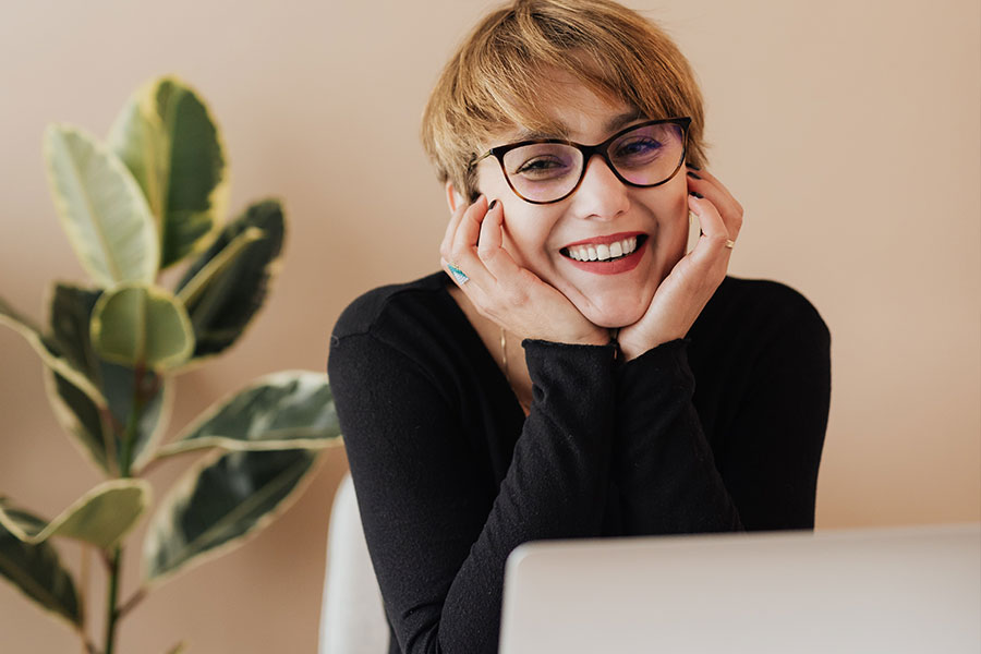 Woman Sitting Behind Laptop Smiling Woman Sitting Behind Laptop Smiling